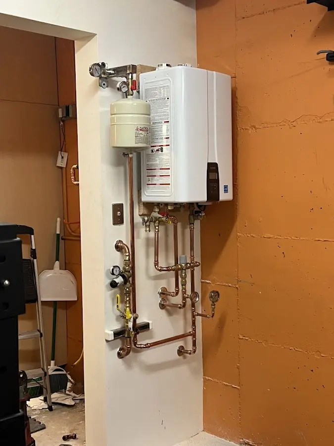 Plumbing technician inspecting water heater connections in Craig